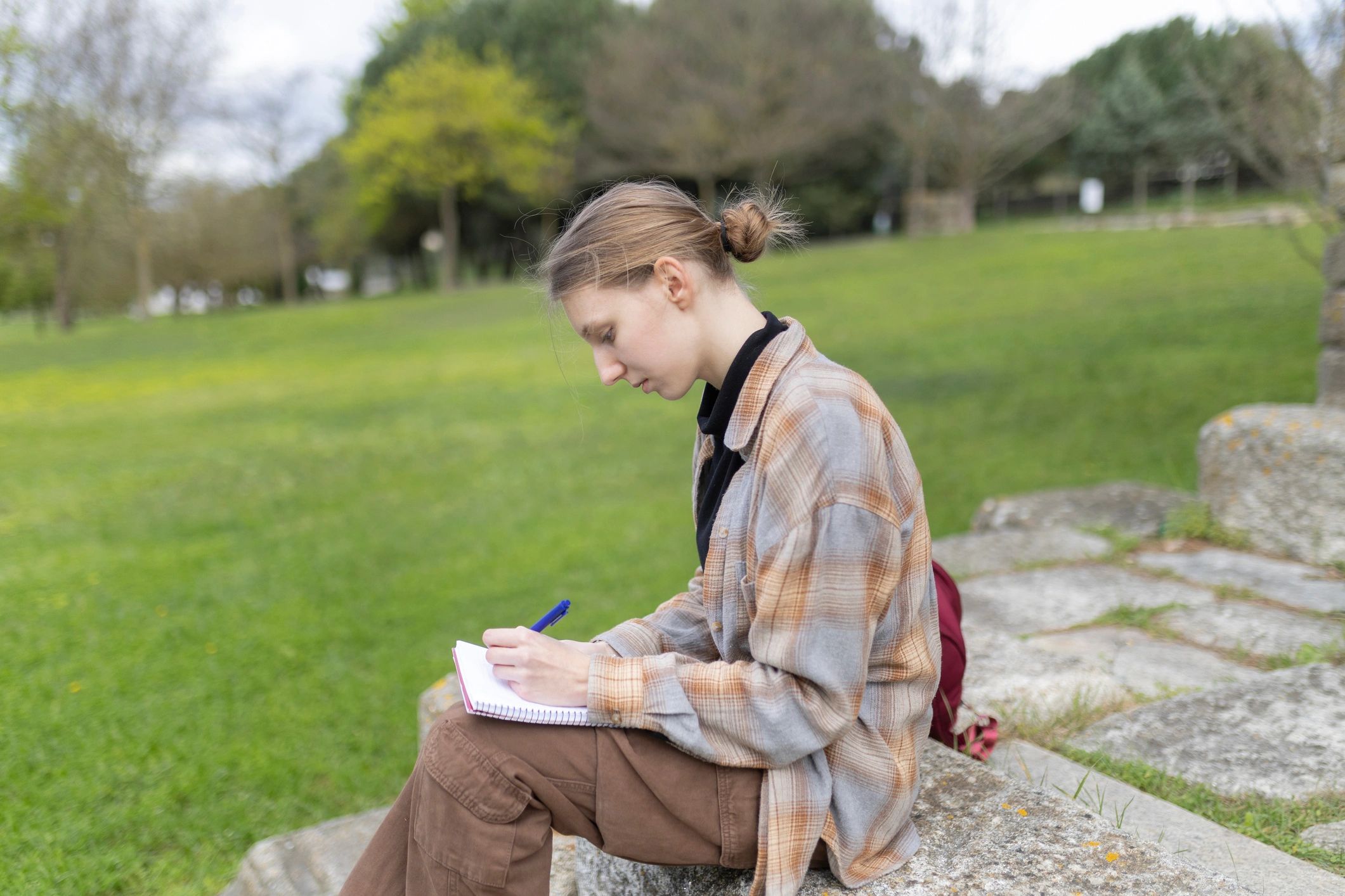 Woman journaling outdoors for clarity and reflection
